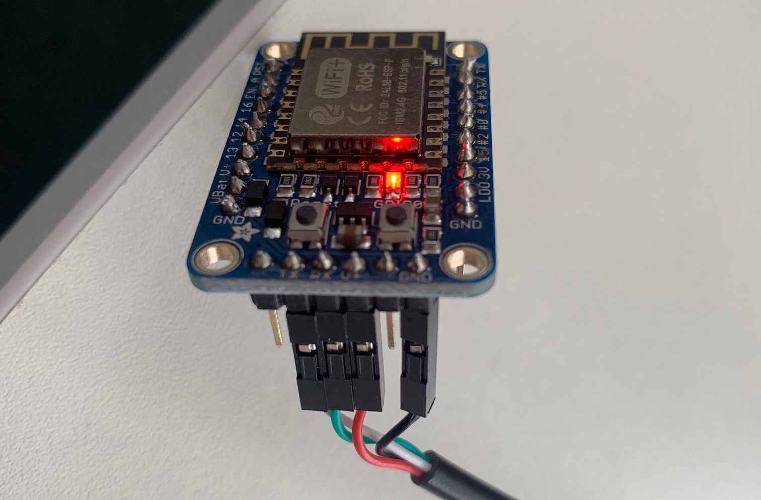Image showing the pins on the Adafruit Huzzah ESP8266 Breakout connecting to white, green, red and black sockets on the Adafruit Huzzah ESP8266 Breakout (check table below)