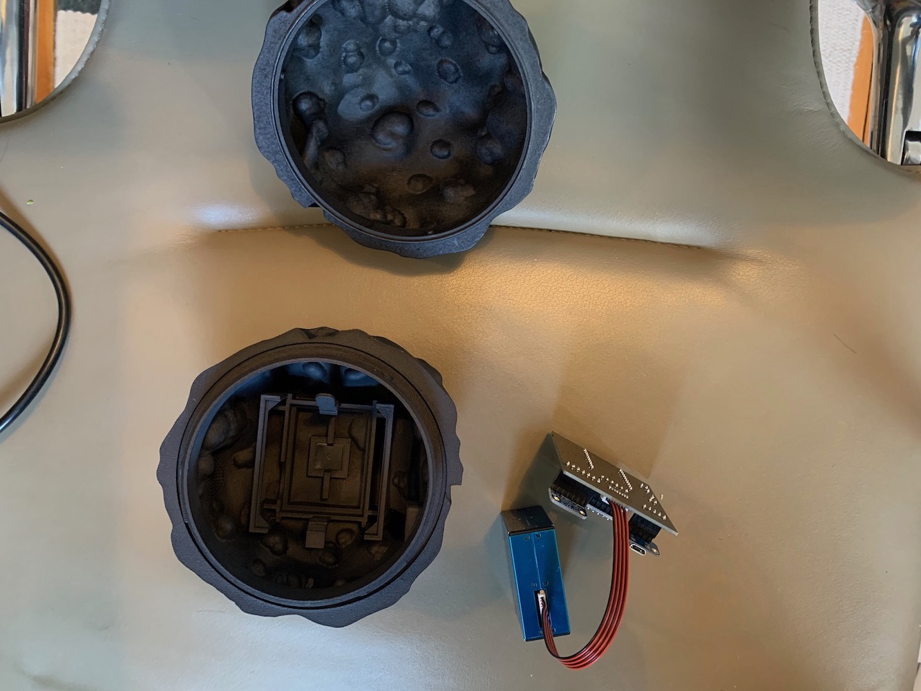 Image showing the top and bottom half of the diesel char Dustbox 2.0 sensor and completed PCB with sensor attached beside it