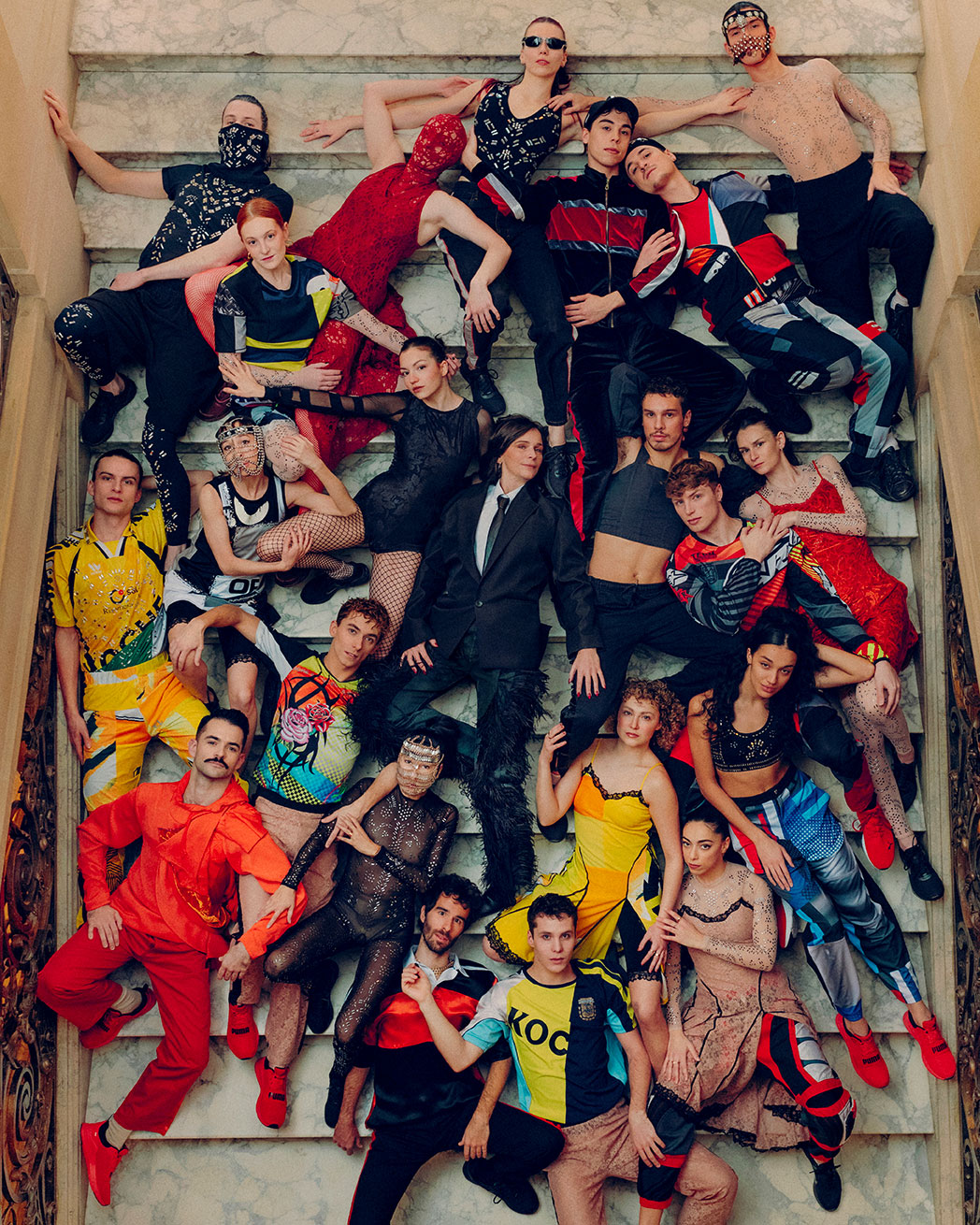 Les danseur·eurs du ballet de Lorraine sont allongé·es dans des escaliers de marbre autour de Maud Le Pladec, la directrice du balai. Iels sont habillé·es avec les costumes du spectacle Static Shot